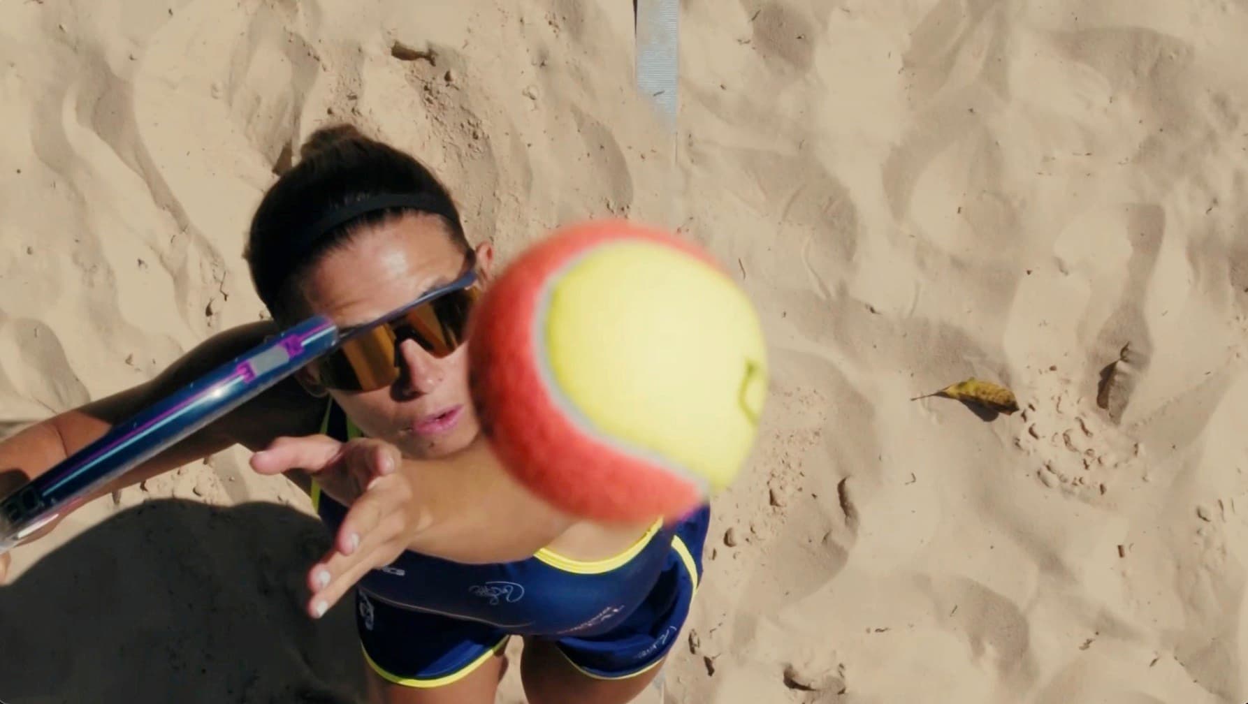 Atleta se preparando para rebater a bola na areia