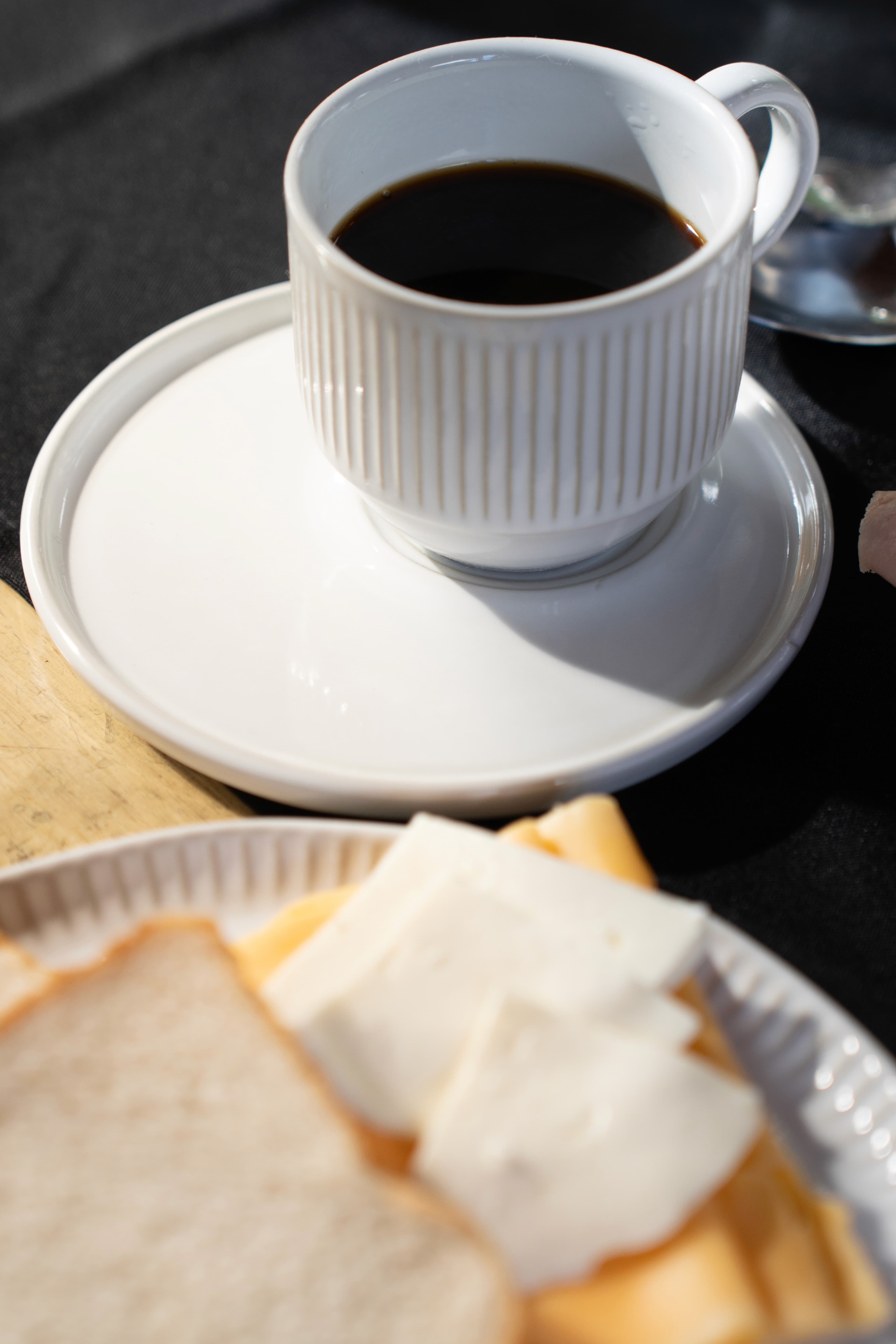 Xícara de café coado e pães do café da manhã servidos na mesa